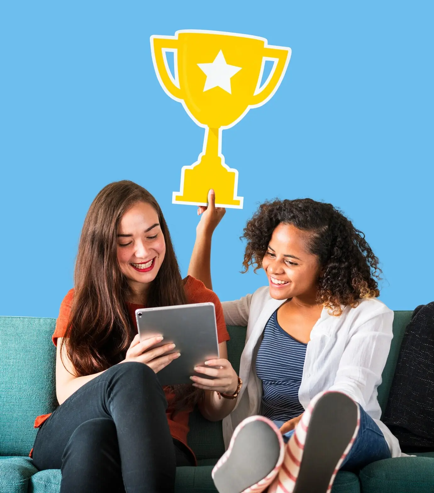 Женщины демонстрируют значок кубка и пользуются планшетом.